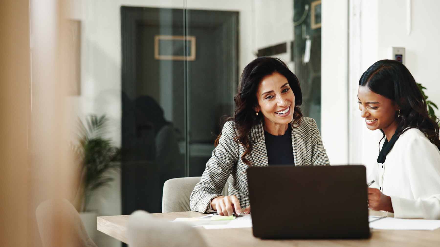 Two professional women looking at laptop